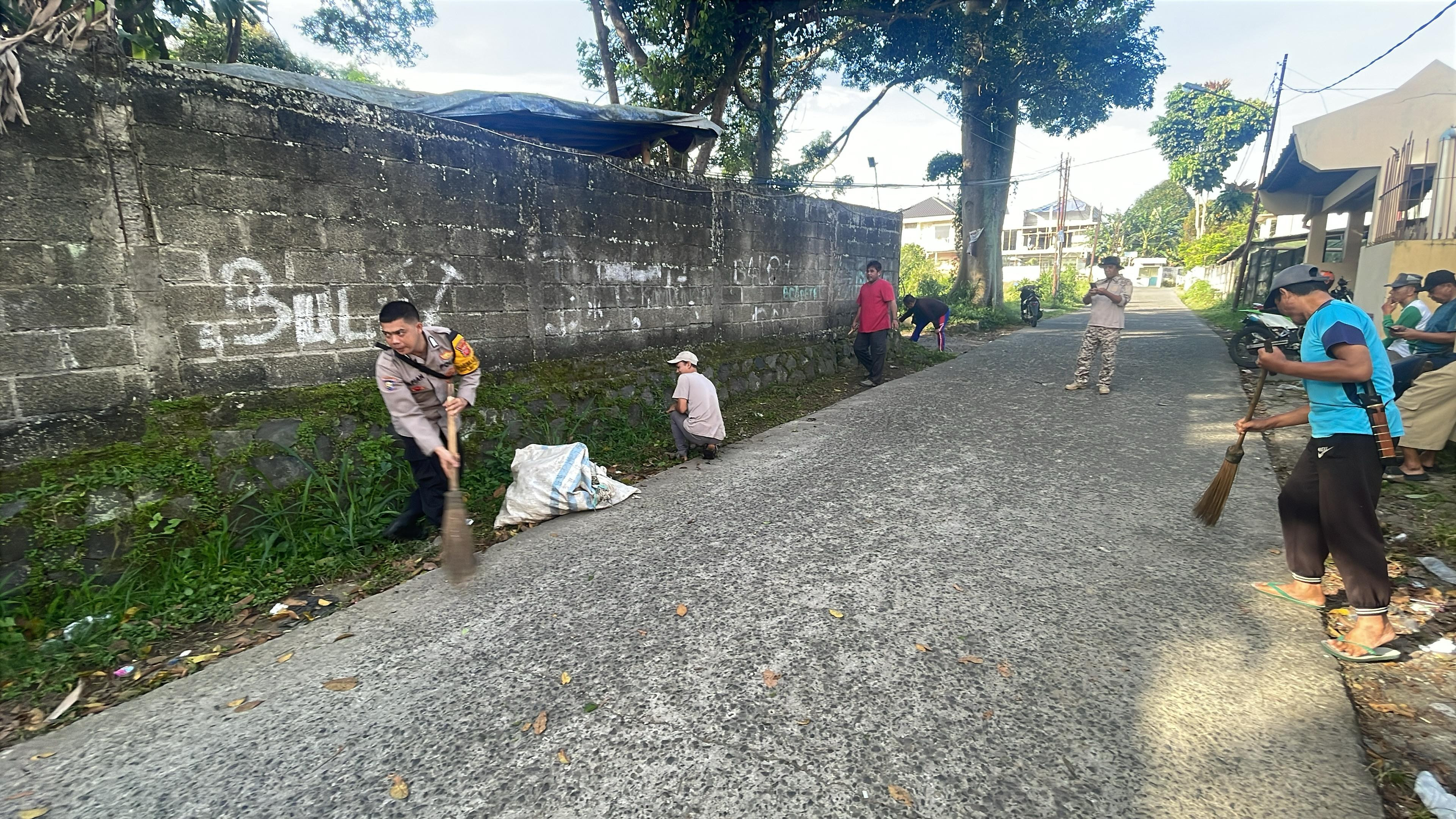 Bhabinkamtibmas Polsek Ciawi Polres Bogor Gotong Royong Bersama Warga Desa Banjarwangi Bersihkan Jalan Lingkungan