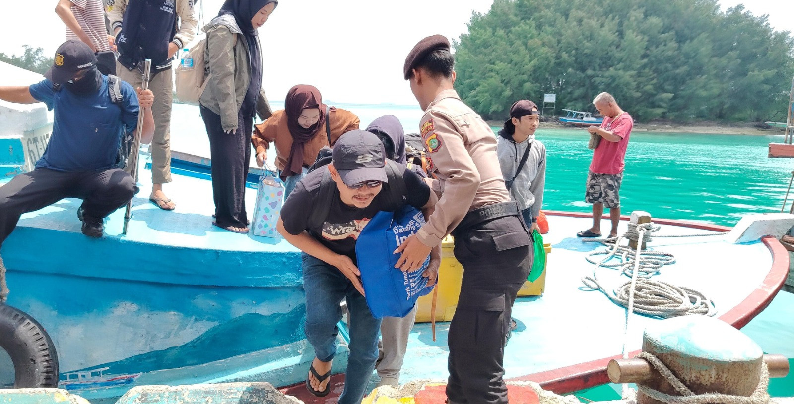 Anggota  Polisi Polsek Kepulauan Seribu Utara Bantu Penumpang di Dermaga Pulau Kelapa