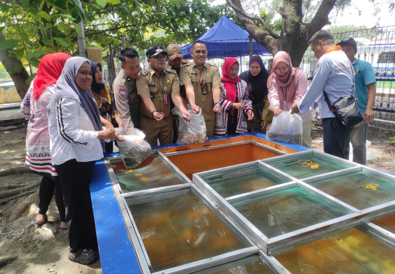 Bhabinkamtibmas Pulau Kelapa Dampingi Lurah Tabur Benih Ikan dalam Program Ketahanan Pangan