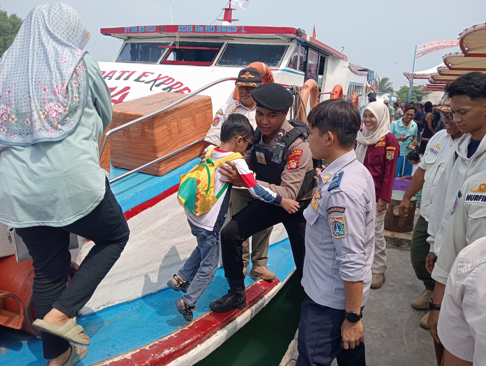 Polisi Baik Polsek Kepulauan Seribu Utara Bantu Penumpang Turun dari Kapal, Tegaskan Pengawasan Ketat Barang Bawaan