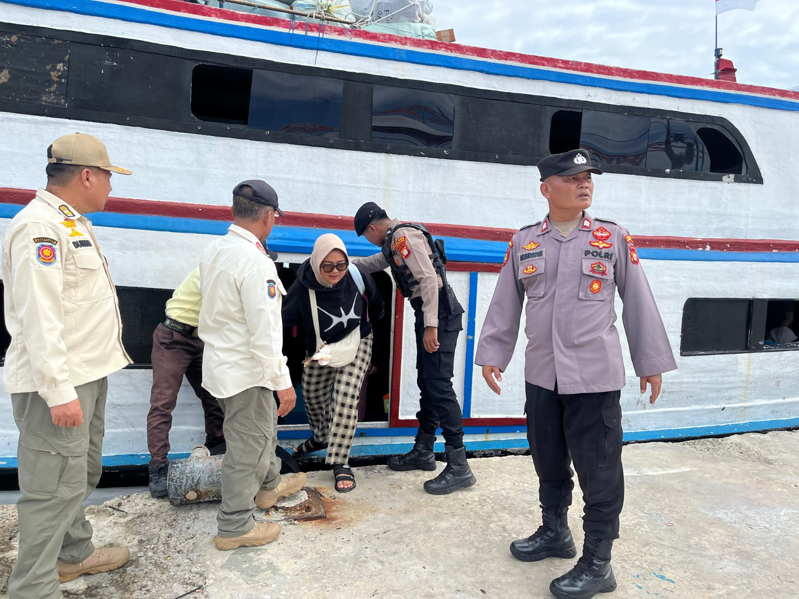 Polisi Baik Polsek Kepulauan Seribu Utara Bantu Penumpang Turun Kapal, Awasi Barang Masuk Cegah Narkoba dan Miras