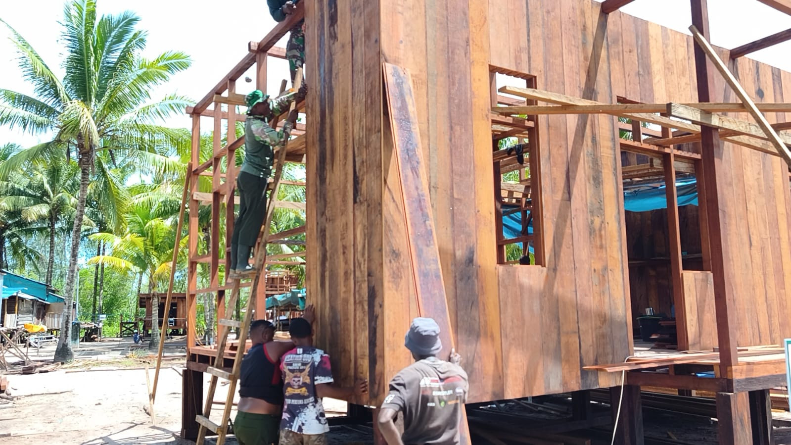 Satgas TMMD dan Warga Kebut Pemasangan Dinding Rumah Niko Makare