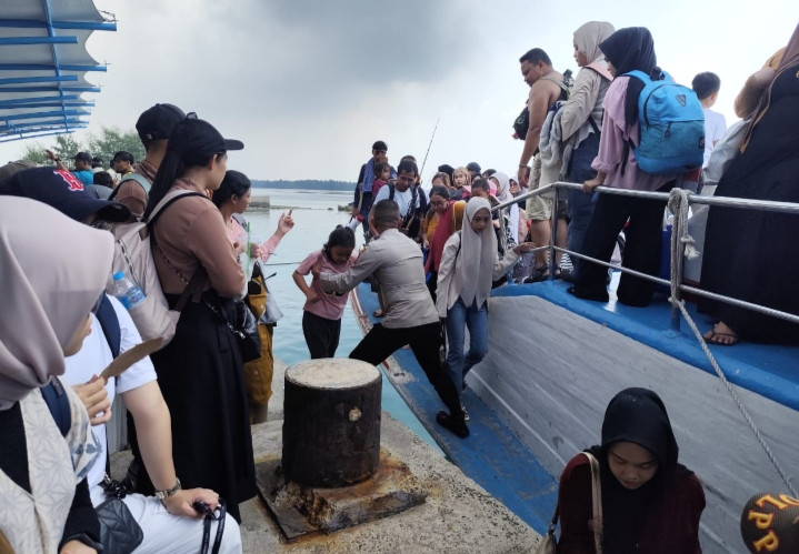 Polisi Baik Bantu Penumpang Turun dari Kapal, Cegah Sajam dan Narkoba Masuk Pulau