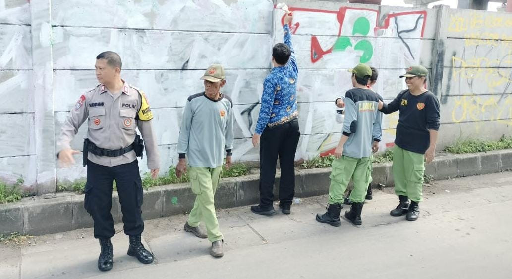 Bhabinkamtibmas Bersama Lurah dan Linmas Laksanakan Pembersihan Tembok