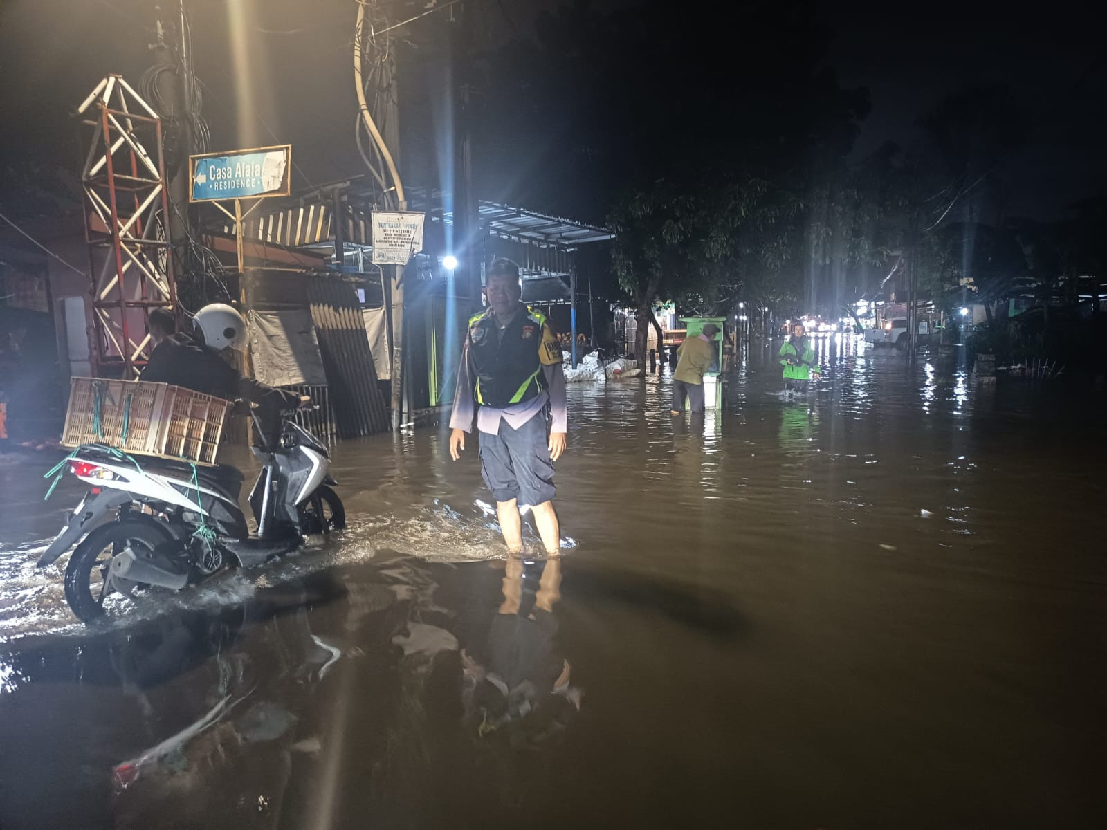 Akses Jalan Jatiluhur Raya Terputus, Bhabinkamtibmas Jakasampurna Siagakan Perahu Karet di Lokasi Banjir