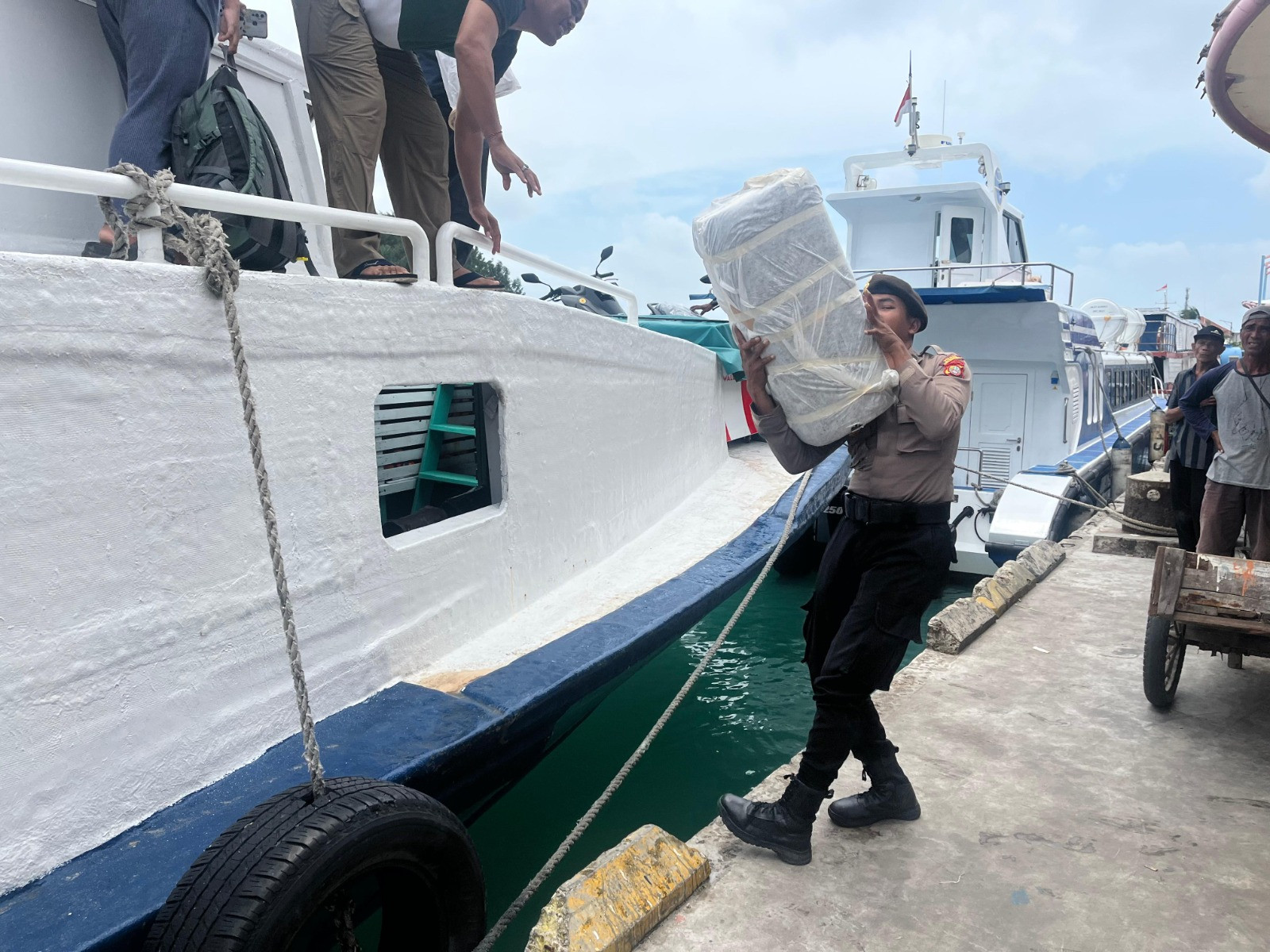 Polisi Baik dan Humanis Bantu Penumpang Turun dari Kapal di Dermaga Pulau Kelapa
