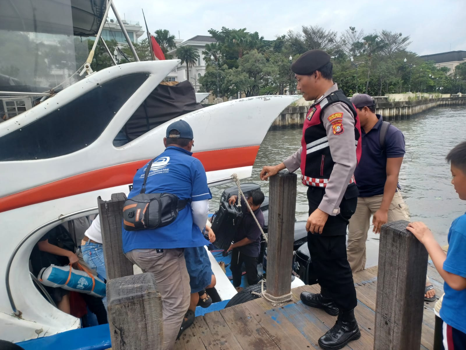 Anggota Polres Kepulauan Seribu Bantu Penumpang Turun dari Kapal di Dermaga 16 Marina Ancol